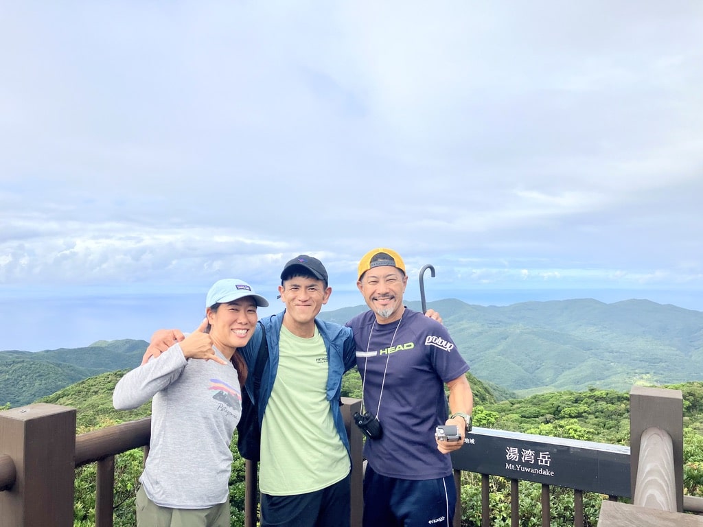奄美大島の湯湾岳ツアーの途中に展望台で写真撮影をする3人組