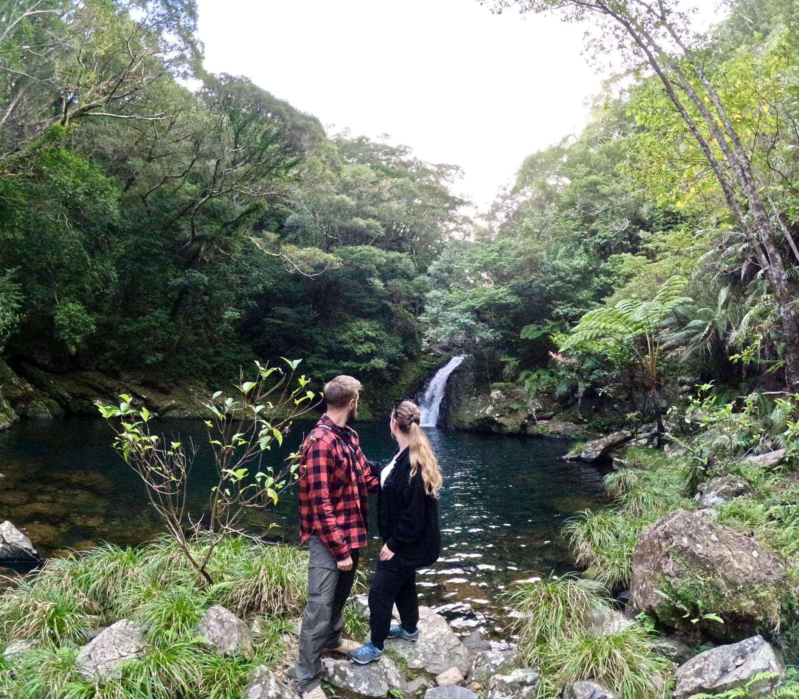 A couple enjoying the view of a waterfall.