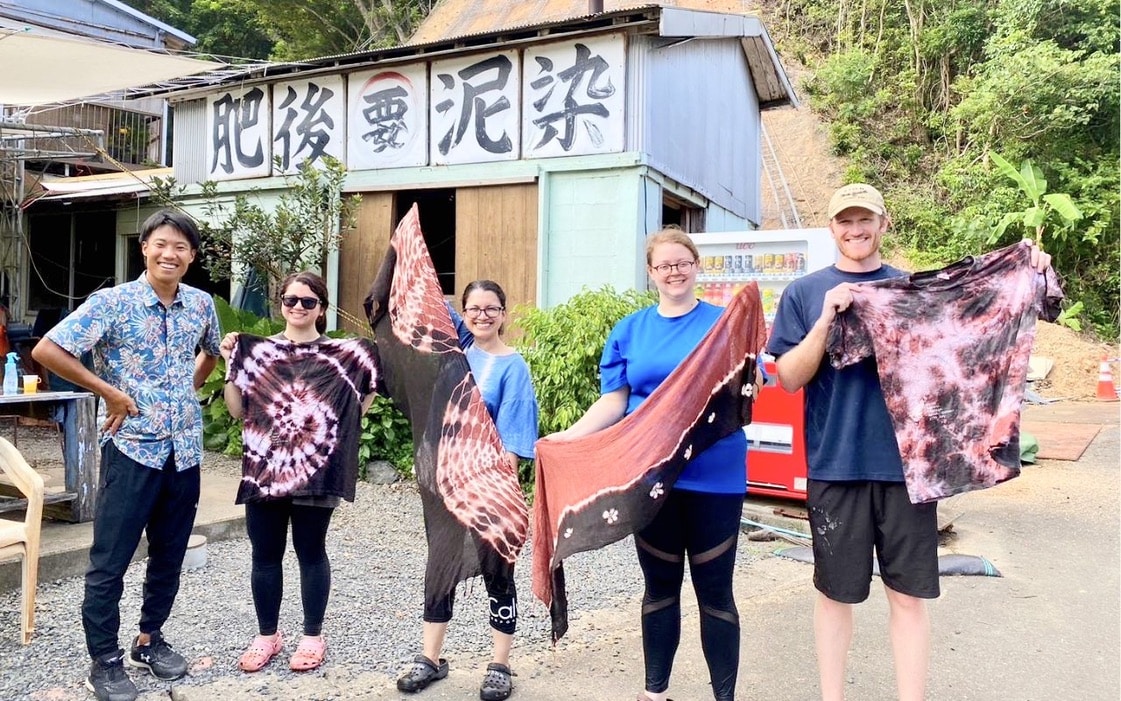 Guests proudly holding their finished mud-dyed textiles after a traditional mud-dyeing experience in Amami Oshima
