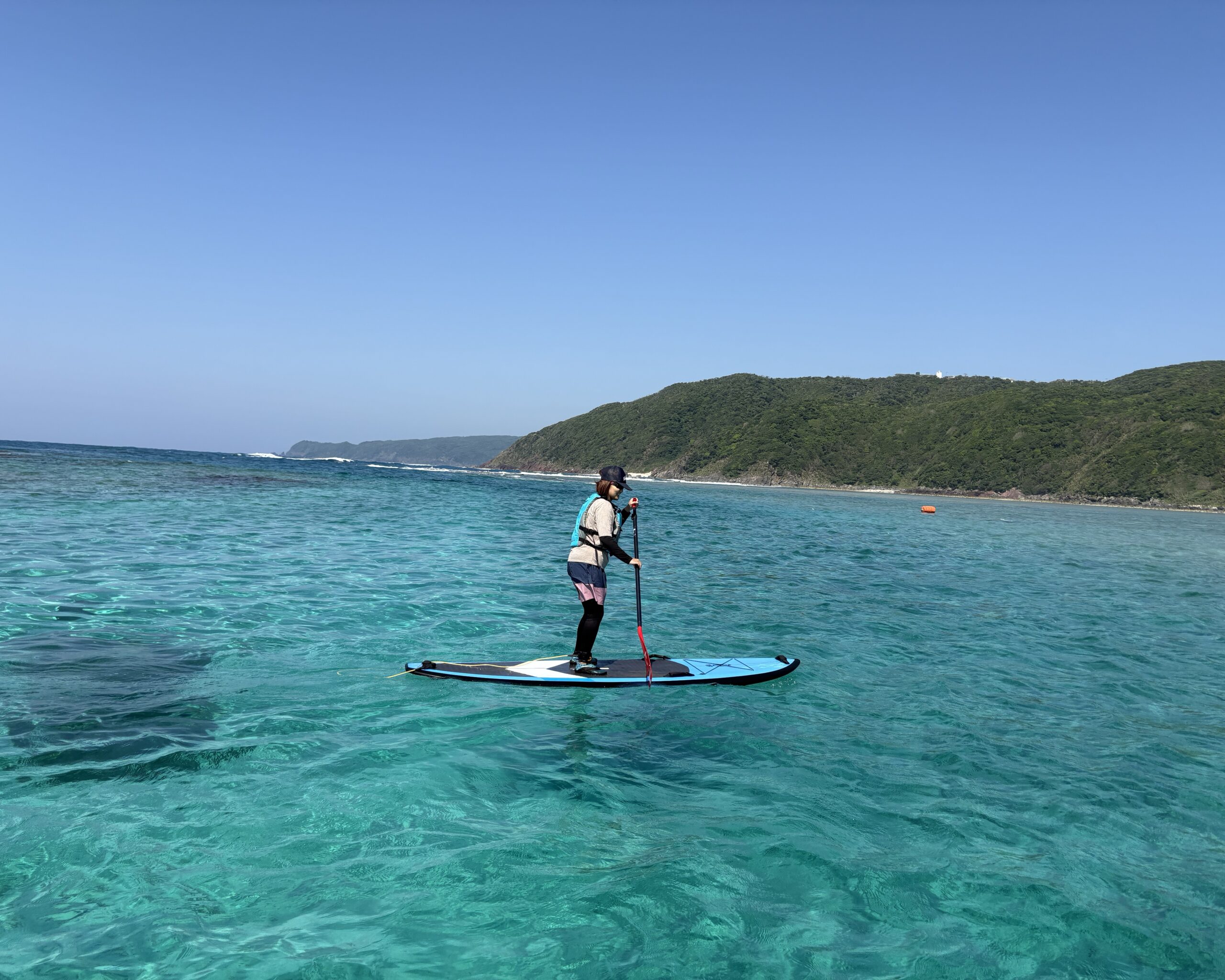 Stand-up paddleboarding on crystal-clear waters off the coast of Amami Island