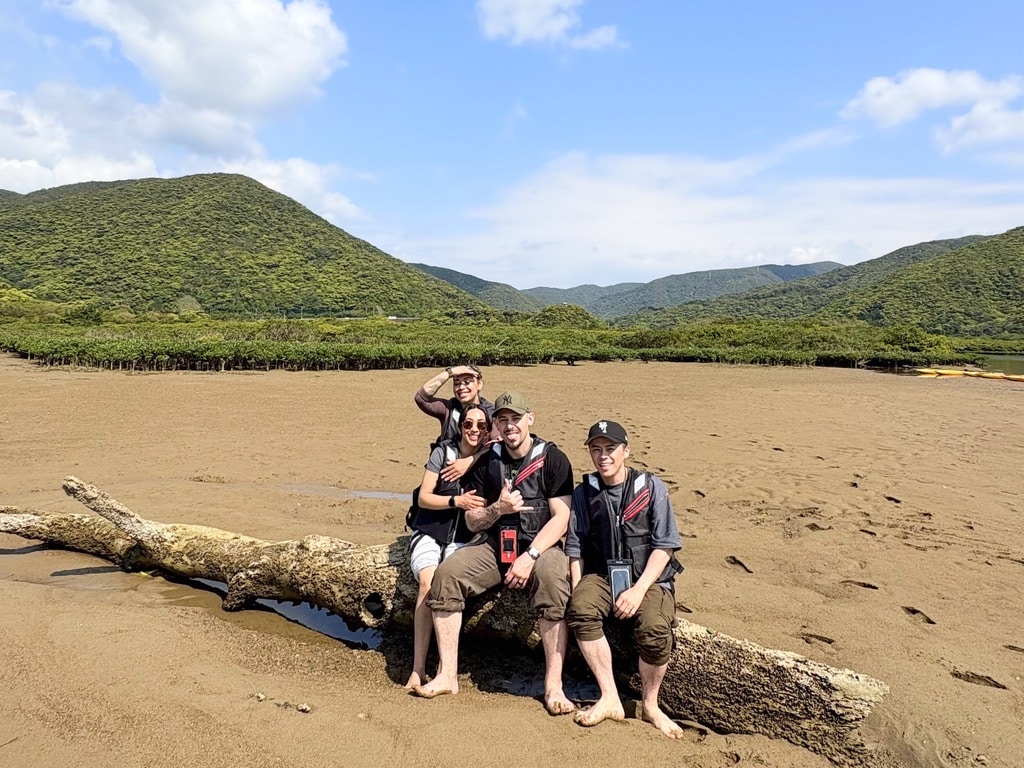 Happy travelers posing on wood during mangrove tour in Amami Oshima