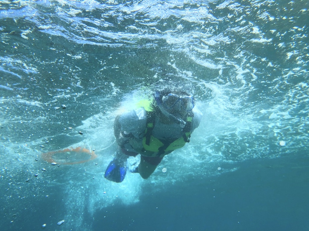 Person snorkeling in clear blue water in Amami Oshima in Summer
