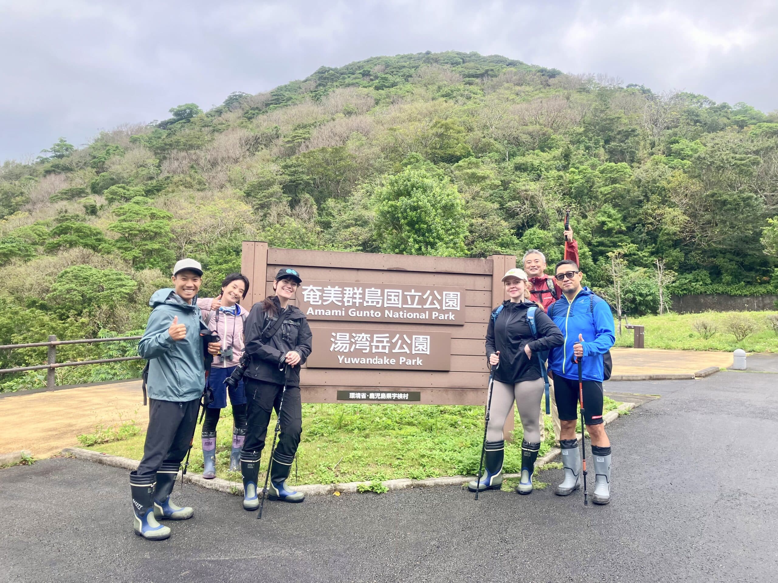 Group of hikers posing at the entrance to Yuwandake Park in Amami Gunto National Park