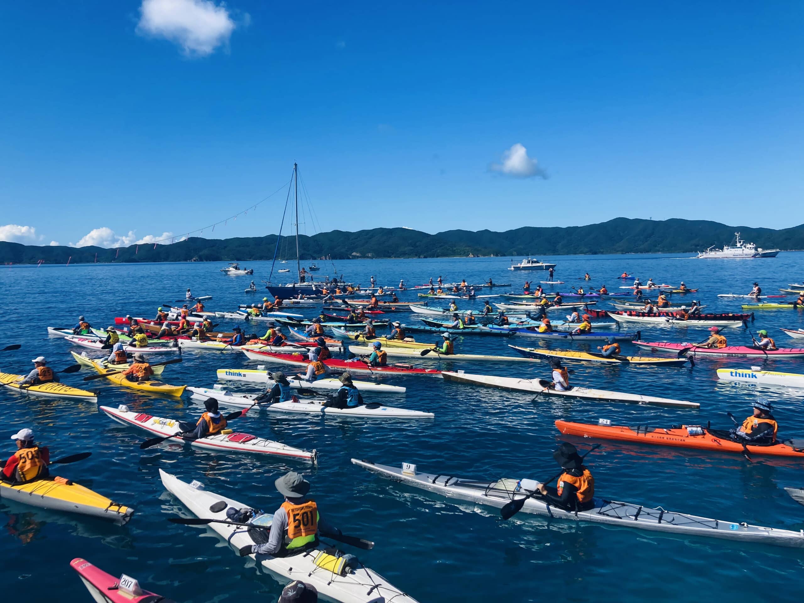 Hundreds of paddlers at the start line of the Amami Seakayak Marathon in calm tropical waters