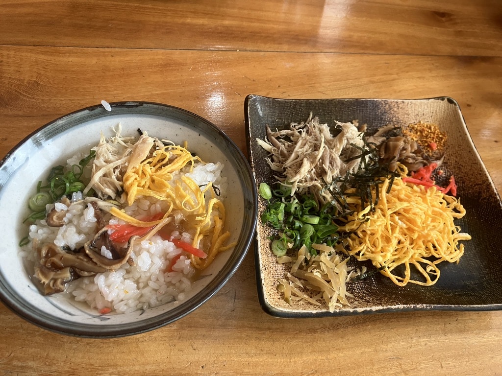 Keihan, a traditional dish of Amami Oshima cuisine, served with chicken, egg, shiitake mushrooms, and clear broth
