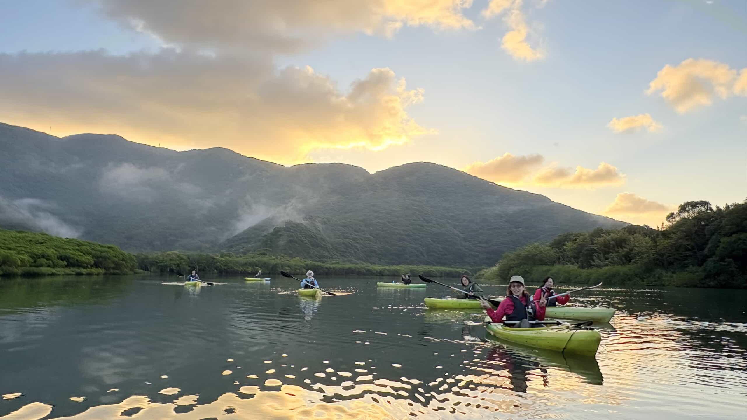朝焼けのマングローブでカヤックを漕ぐ人々