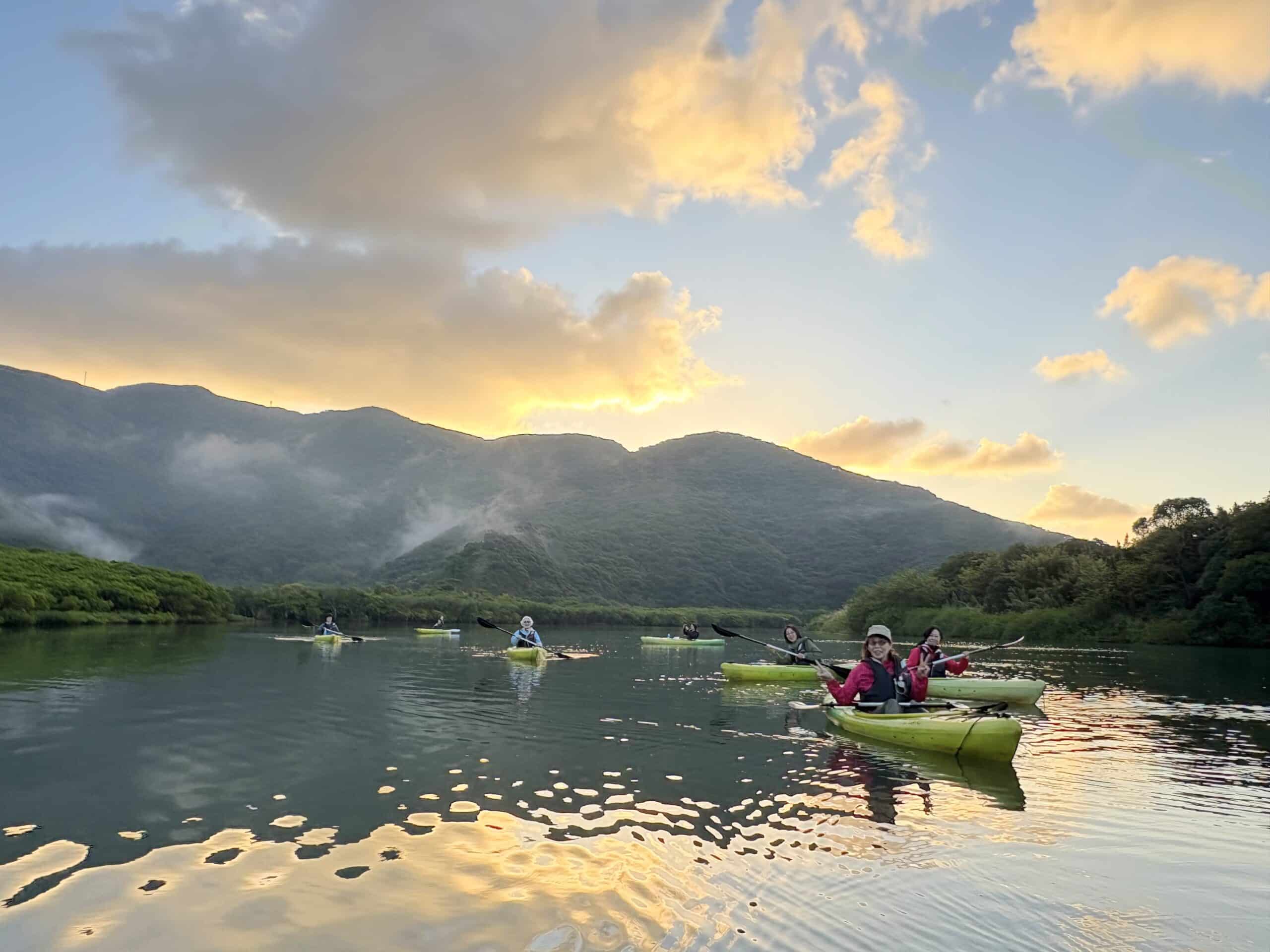 朝焼けのマングローブでカヤックを漕ぐ人々